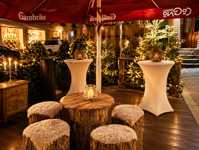Winterlounge der CoCoNo Bar bei Nacht mit Lichterketten und geschmückten Tannen